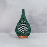 "Sitting, front-facing, empty COPPER AND FOREST GREEN TEARDROP planter, showcasing its elegant design and deep green forest pattern."
